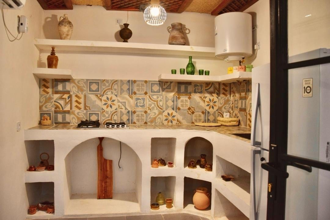 نشیمن و پذیرایی سنتی با صندلی‌های چوبی در بوم‌گردی مغرب قشم