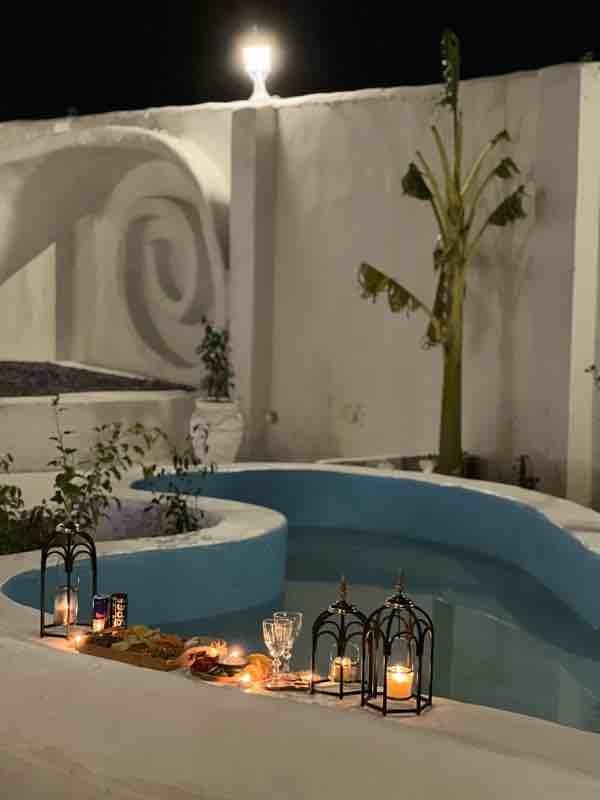 استخرِ مجموعه با نورِ شمع و گیاهان در شبِ بوم‌گردی مدیترانه سمیره واحد ۳ قشم