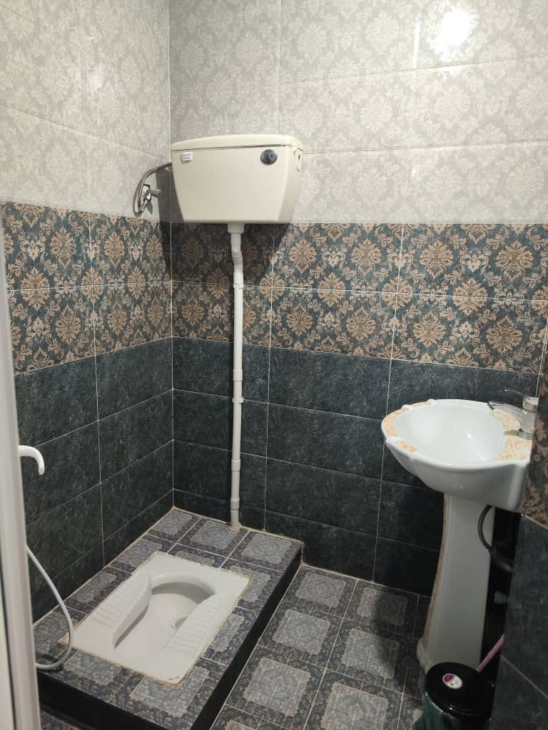 حمام با کاشی روشن و سردوش در سوئیت قشم