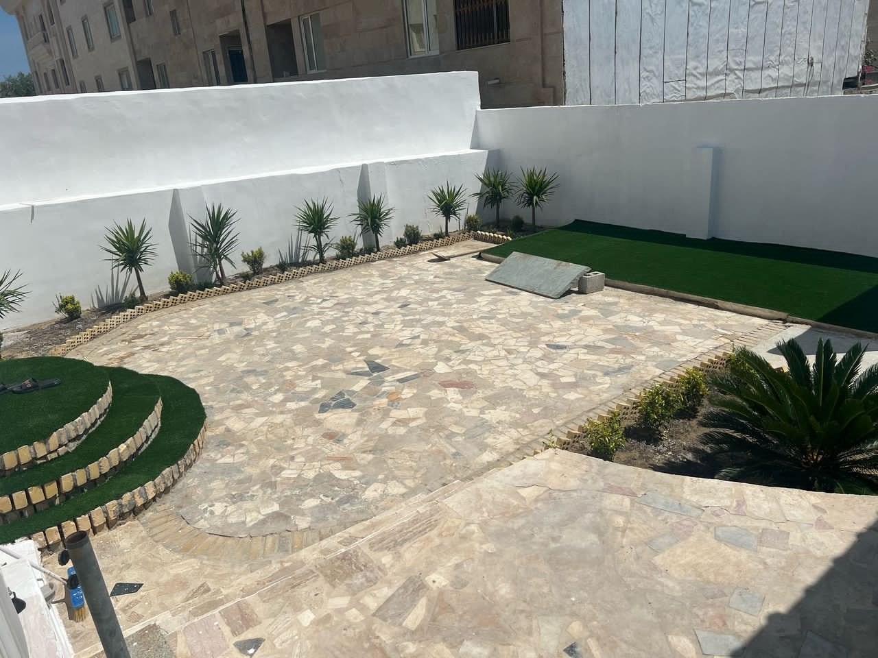 حیاط روباز با شن و فضای سبز در آپارتمان با استخر قشم