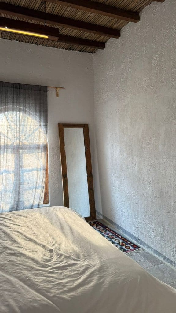 اتاق سفید با درگاهِ قوسی و طاقچهٔ دیواری در بوم‌گردی ملو قشم