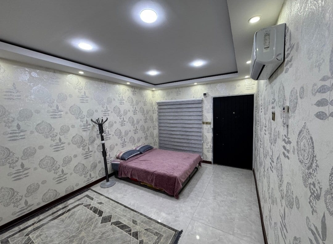 اتاق با رخت‌خواب سنتی و کاغذدیواری گل‌دار در سوئیت سپهر قشم