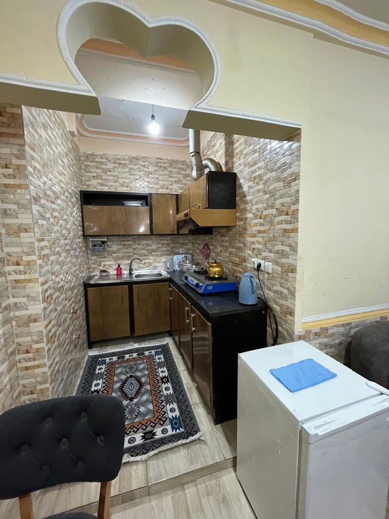 آشپزخانه با کابینت، اجاق گاز و فرش در واحد ۴ اقامتگاه سنتی برگ سبز قشم