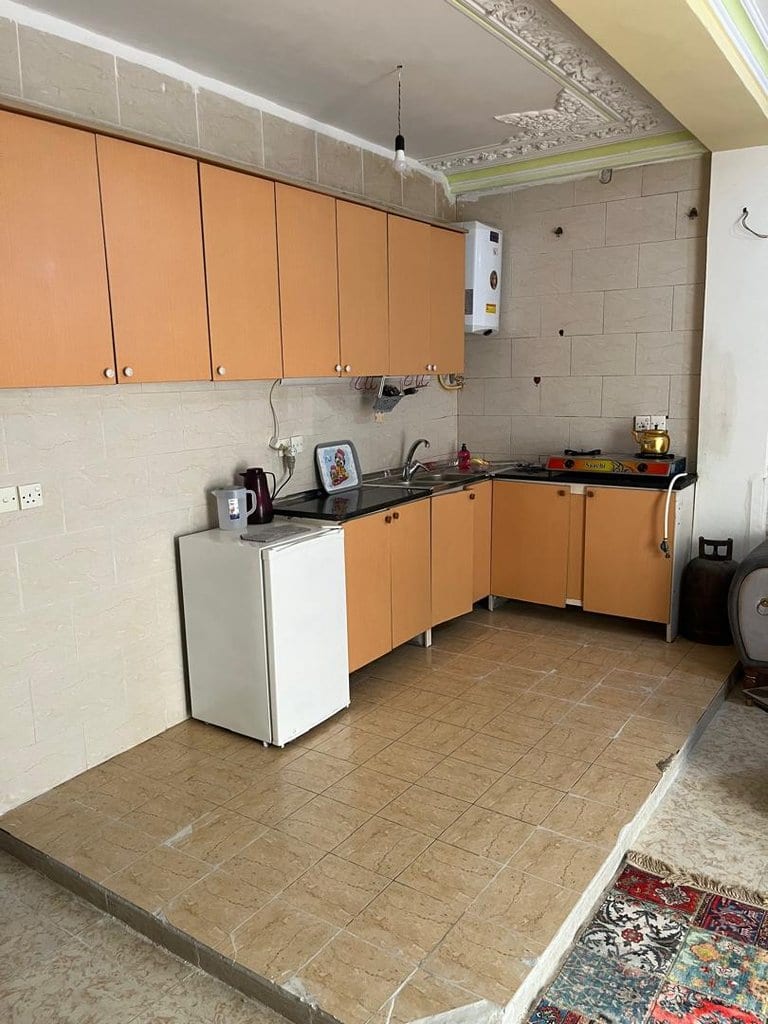 آشپزخانه با کابینت، یخچال و اجاق گاز در واحد ۷ مجتمع برگ سبز قشم