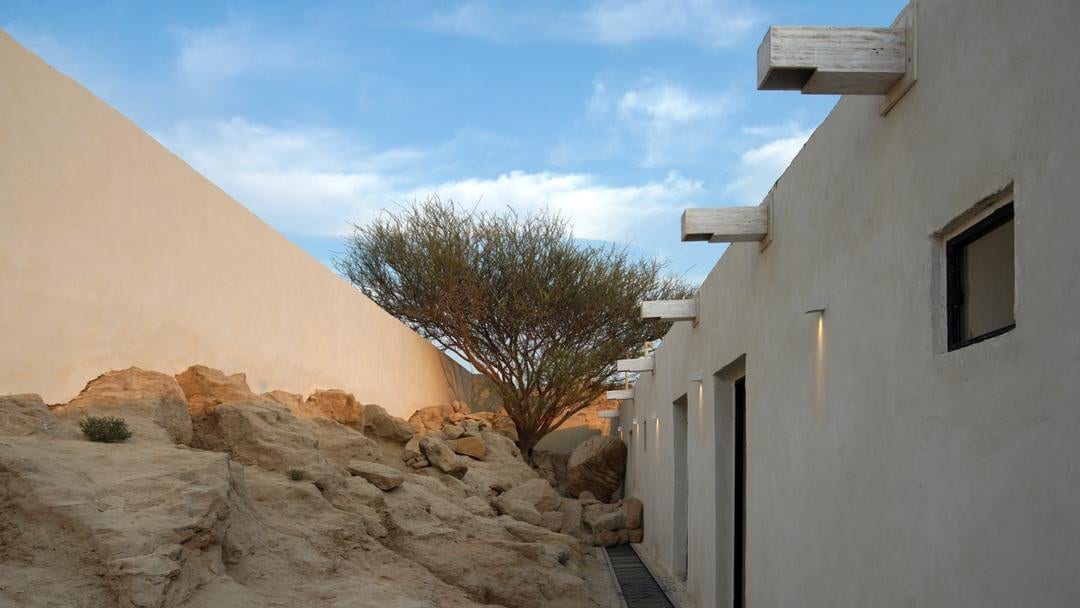 حیاط با درخت بومی در برابر آسمان آبی در ویلا مغاک قشم