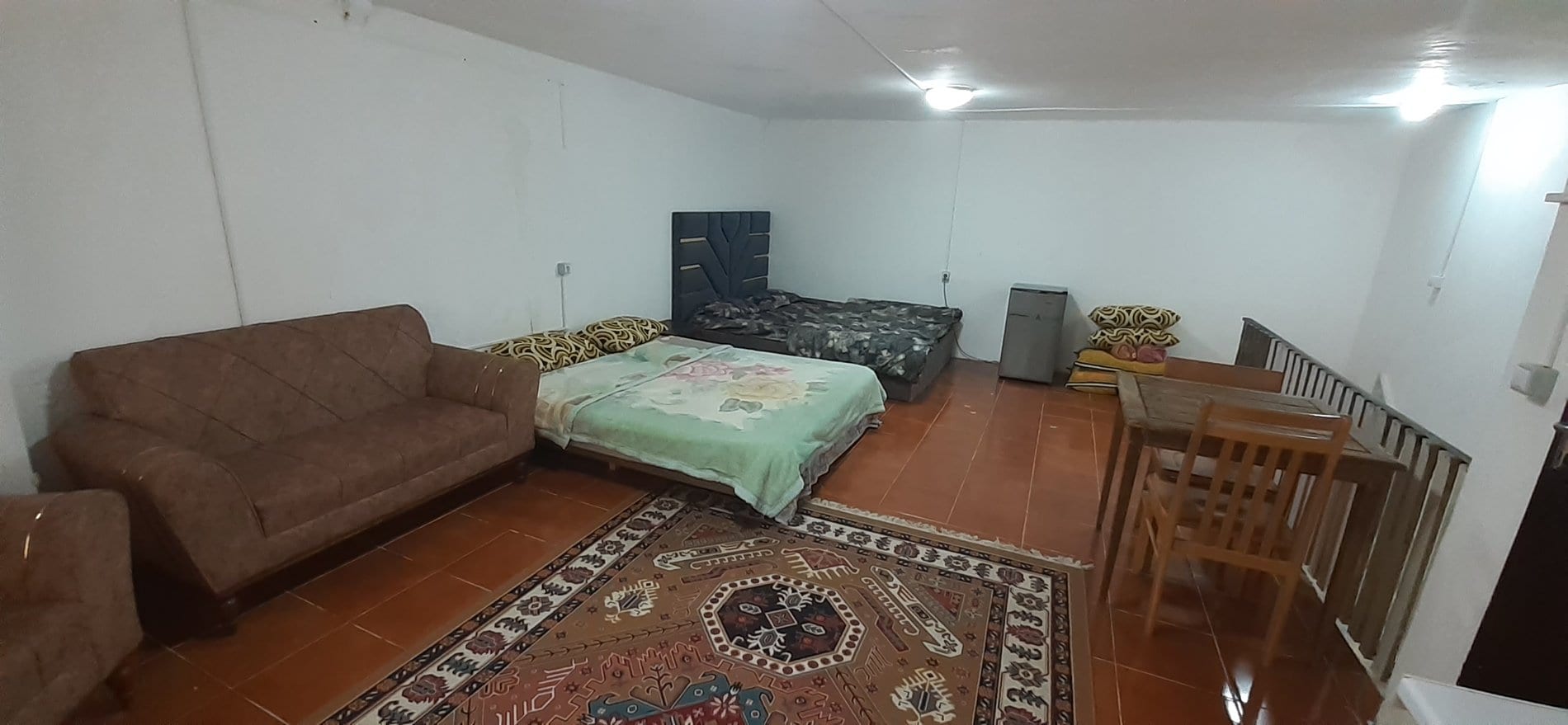 اتاق‌خواب با رخت‌خواب سبز و فرش در واحد ۷ نخل زرین قشم