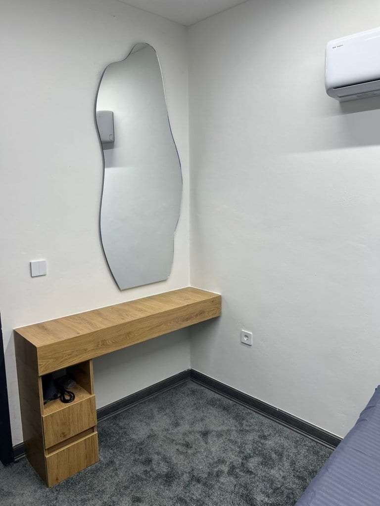 اتاق‌خواب با تخت دونفره و روتختی روشن در آپارتمان سام پلازا قشم