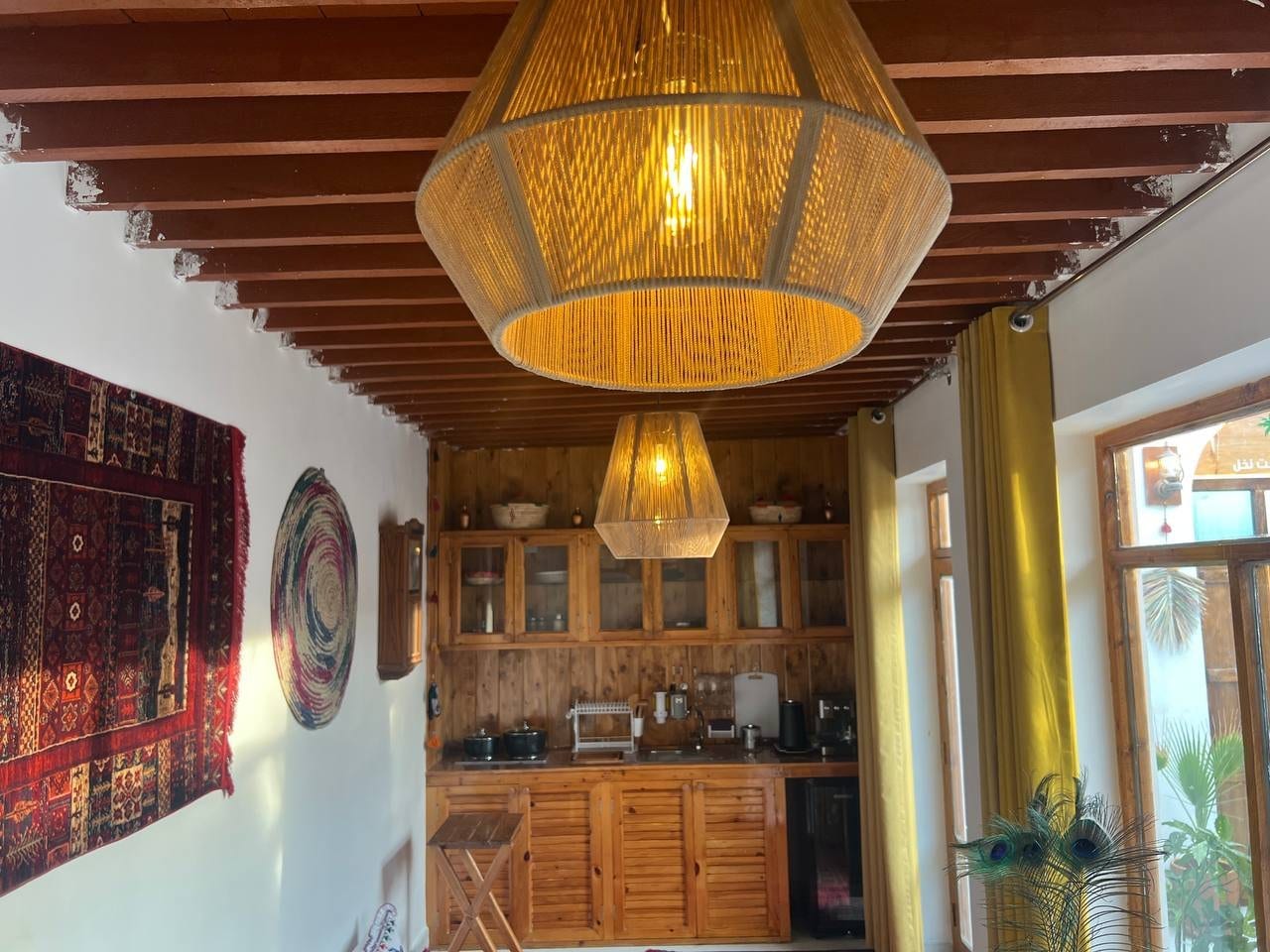 چراغ آویز بزرگ و تزئینی سنتی روی سقف تیرچوبی در ویلای قشم