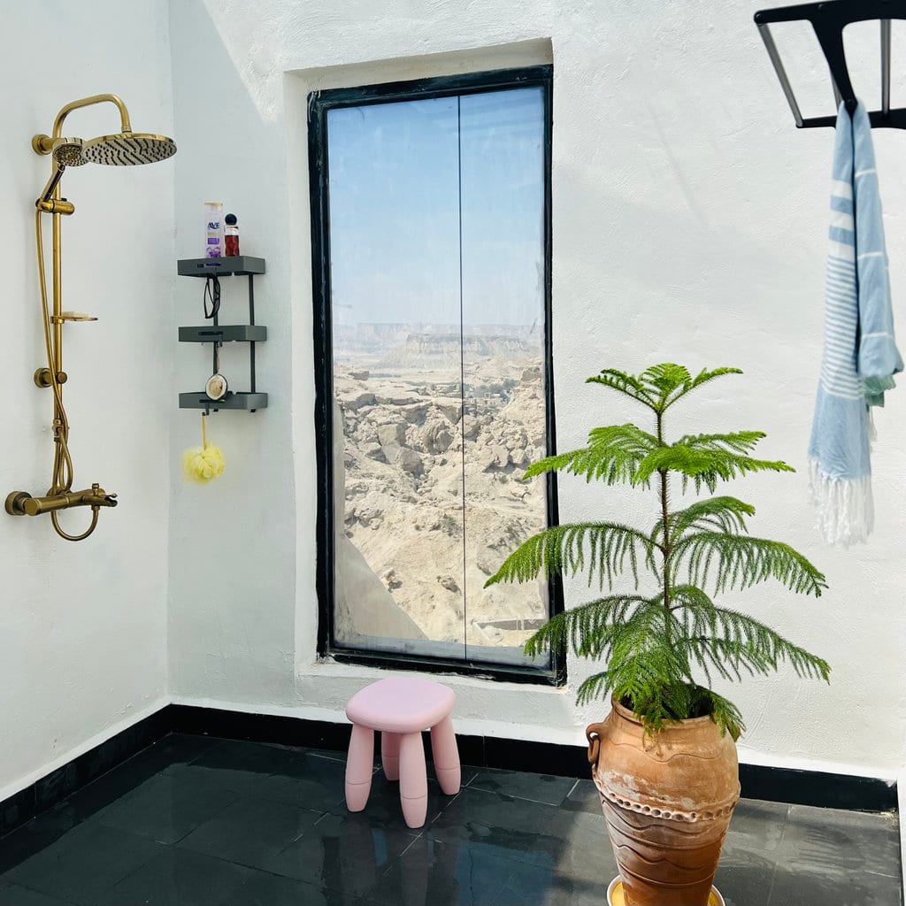 اتاق‌خواب با روتختی سبز و پنجرهٔ رو به منظره در ویلا ساحارا قشم